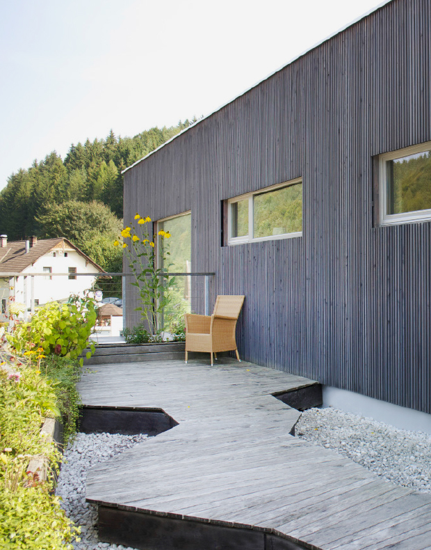 Moderne Fassade aus Lärchenholz mit Dachterrasse und Dielenboden samt Pflanzbehältern in Lärche