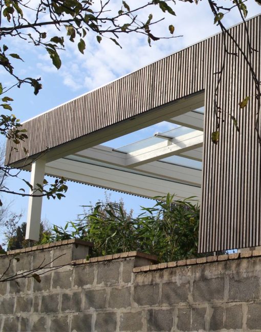 Moderne Terrassenüberdachung in Lärche mit Glas und Leisten / Lamellenfassade aus Holz