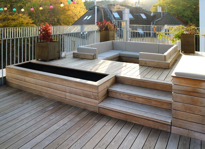 Aus unseren Referenzen: Exklusive Holz-Terrasse mit Holzdielen aus Thermoesche mit integrierter Lounge-Sofa-Landschaft von WALLI